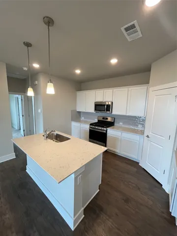 a large kitchen with kitchen island a stove a sink a refrigerator and a living room view