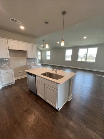 a kitchen with wooden floors and white appliances
