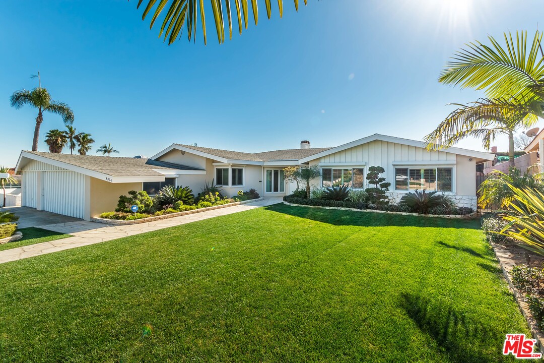 a front view of house with yard and outdoor seating