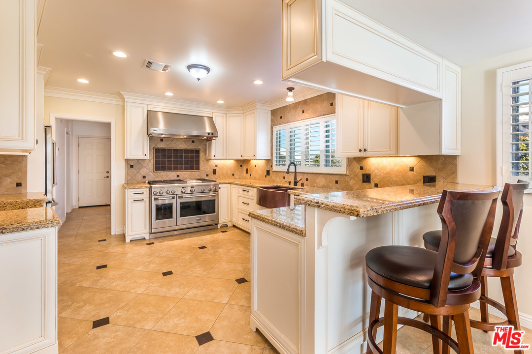 4304 Olympiad Drive View Park, CA 90043 - Photo 20 of 44 a kitchen with stainless steel appliances granite countertop a sink counter space and a window