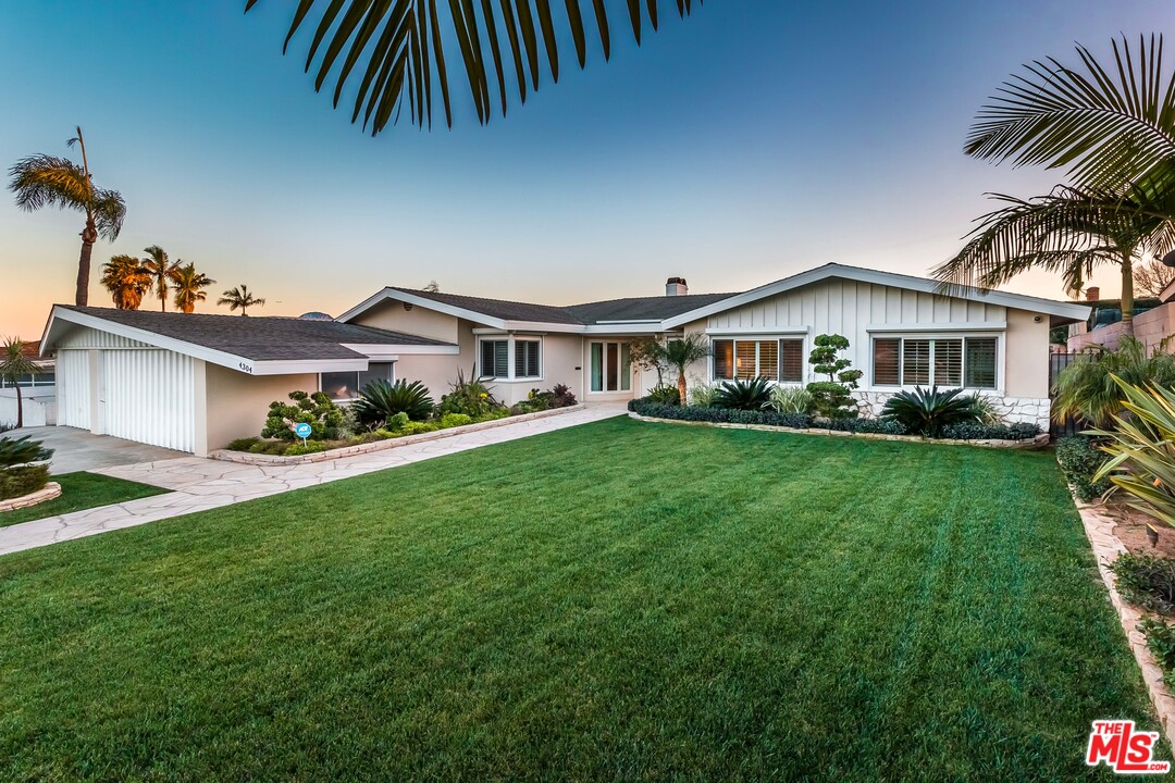 4304 Olympiad Drive View Park, CA 90043 - Photo 38 of 44 a front view of a house with a yard and potted plants
