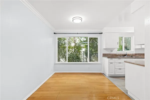 a view of a kitchen with a sink and dishwasher with wooden floor