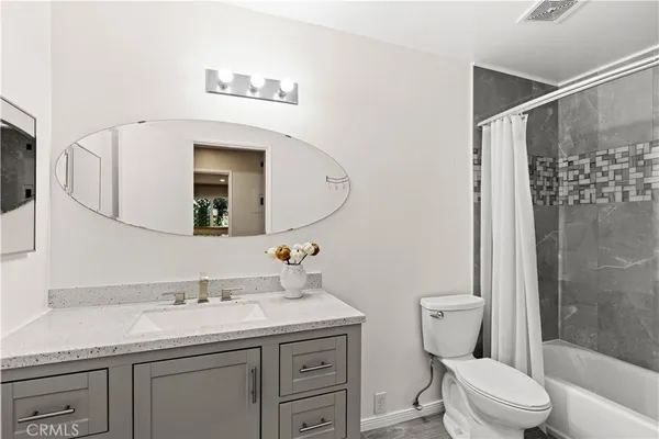 a bathroom with a granite countertop sink mirror vanity and toilet