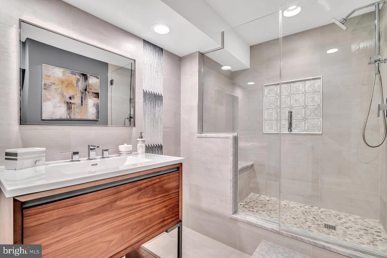 17 Banyan Road Skillman, NJ 08558 - Photo 45 of 53 a bathroom with a sink a mirror a glass door and shower