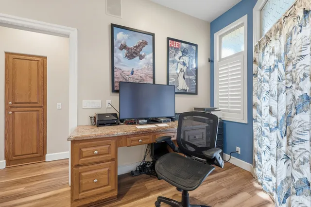 a view of a workspace with furniture and a window