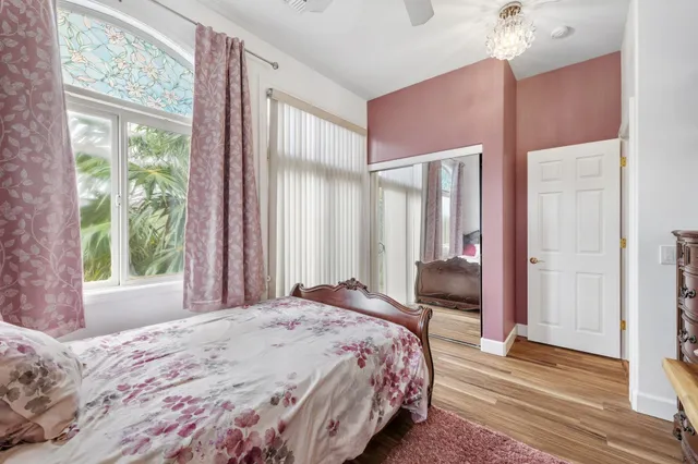 a bedroom with a bed chandelier and a window