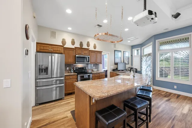 a large kitchen with kitchen island a large counter space stainless steel appliances and furniture