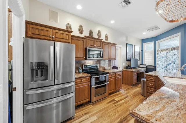 a kitchen with stainless steel appliances granite countertop a refrigerator stove and oven