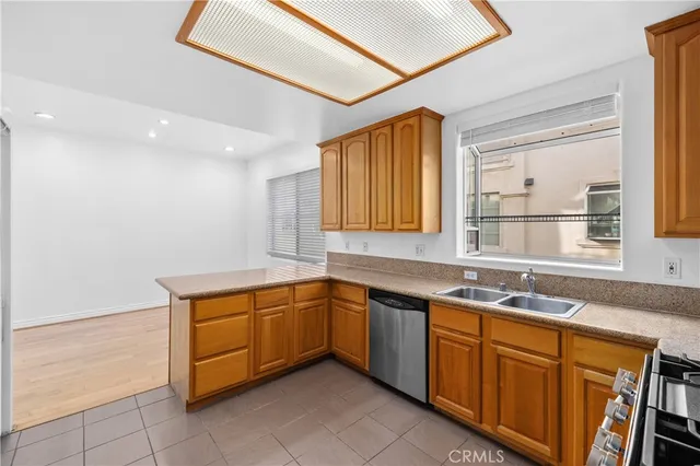 a kitchen with stainless steel appliances granite countertop wooden cabinets a stove top oven a sink and dishwasher