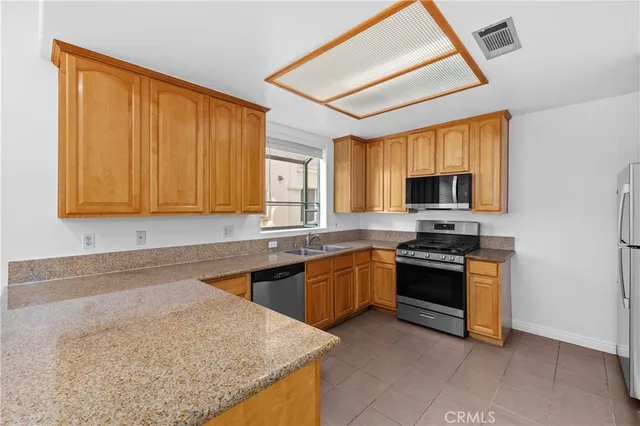 a kitchen with stainless steel appliances granite countertop a stove a sink and a microwave