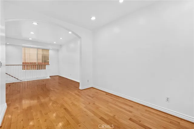 a kitchen with stainless steel appliances granite countertop a refrigerator a stove and a sink with wooden floor