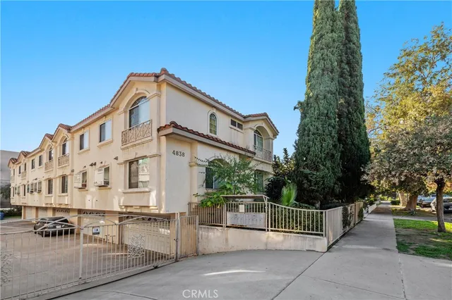 a city street with tall buildings and a cars parked