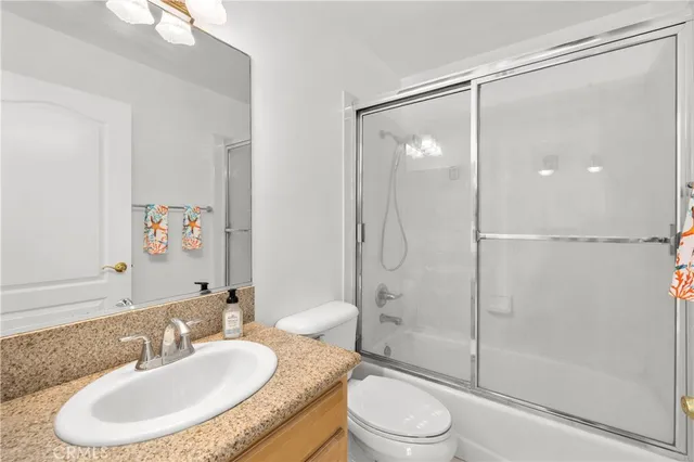 an empty room with wooden floor closet and windows