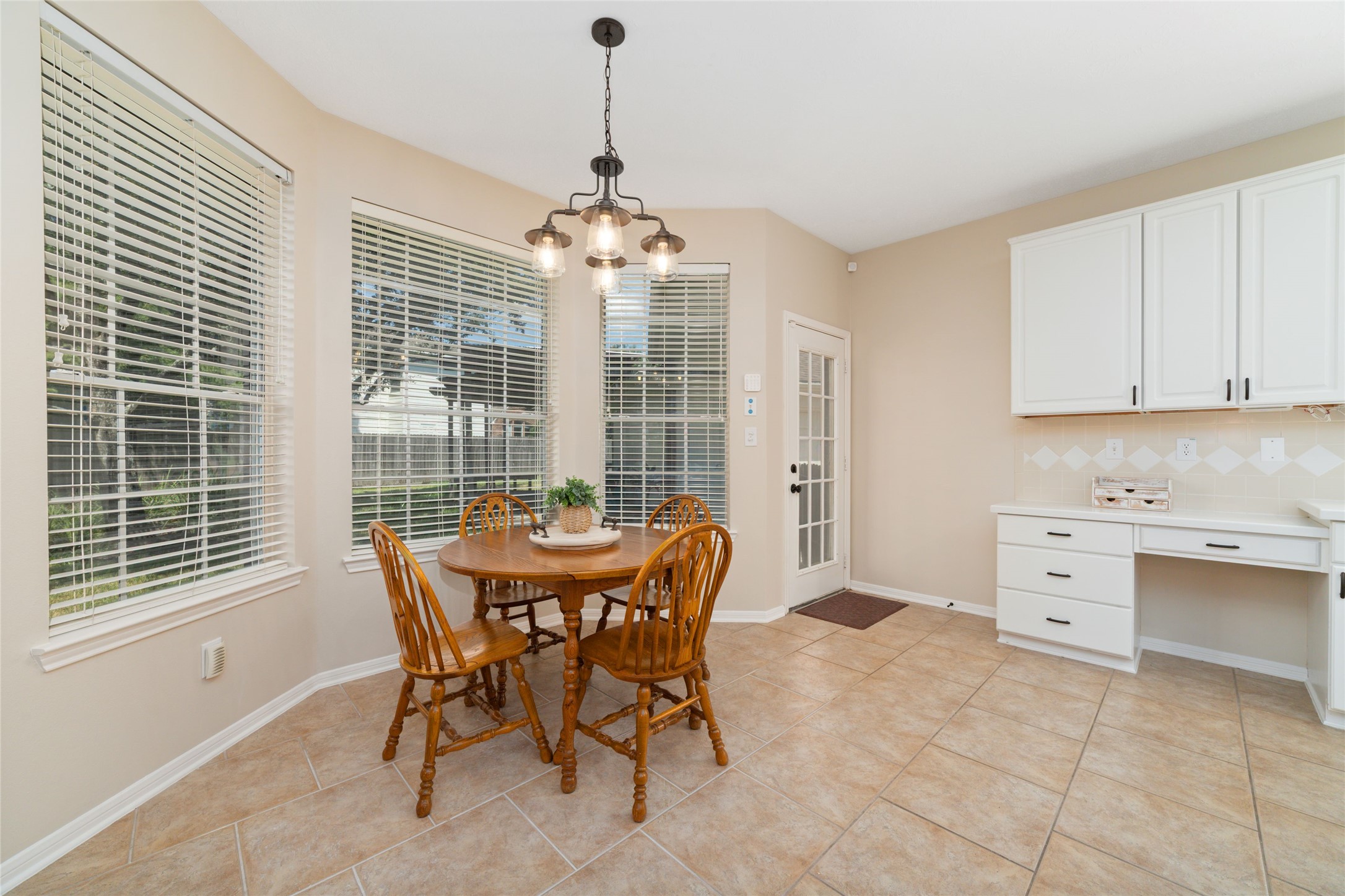 20423 Forest Drive Spring, TX 77388 - Photo 18 of 44 Bright breakfast area featuring large bay windows that overlook the backyard, a convenient built-in desk space, and modern updated lighting.