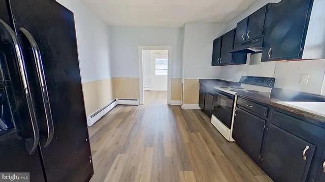 a kitchen with stainless steel appliances a refrigerator and wooden floor
