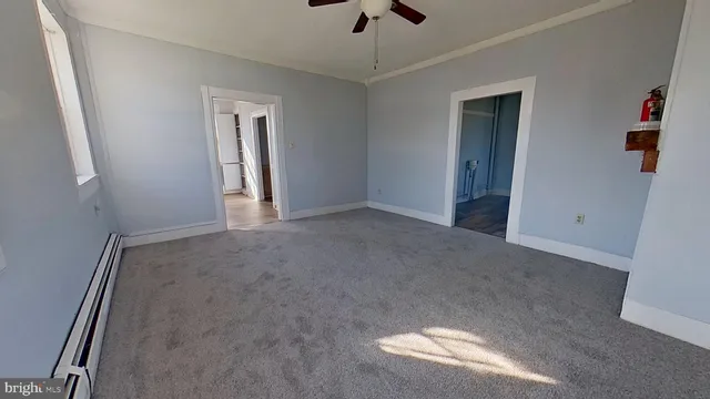 an empty room with ceiling fan and window