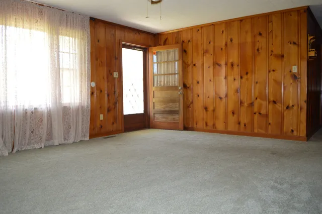 a view of a livingroom with a chandelier fan and windows