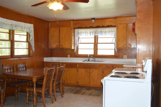 a kitchen with a stove a sink a dining table and chairs