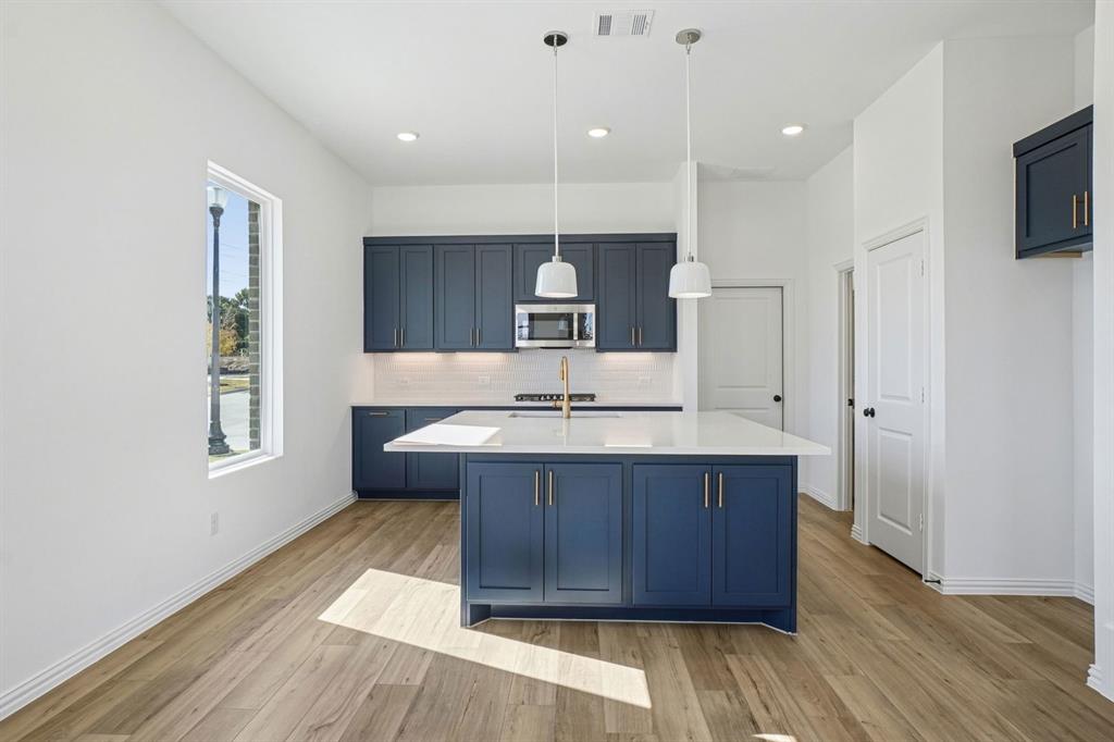 a kitchen with a sink a window and wooden floor