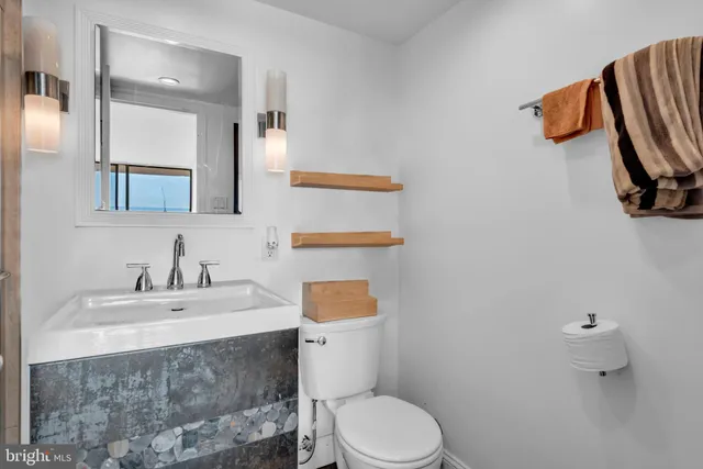 a bathroom with a toilet sink and mirror