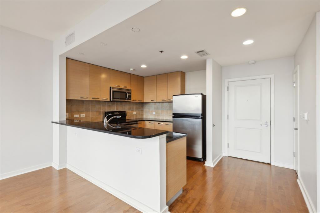 1200 Main Street, Unit 2302 Dallas, TX 75202 - Photo 7 of 22 a kitchen with stainless steel appliances granite countertop a refrigerator a stove top oven a sink and dishwasher