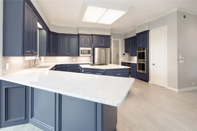a kitchen with kitchen island granite countertop a sink and a refrigerator