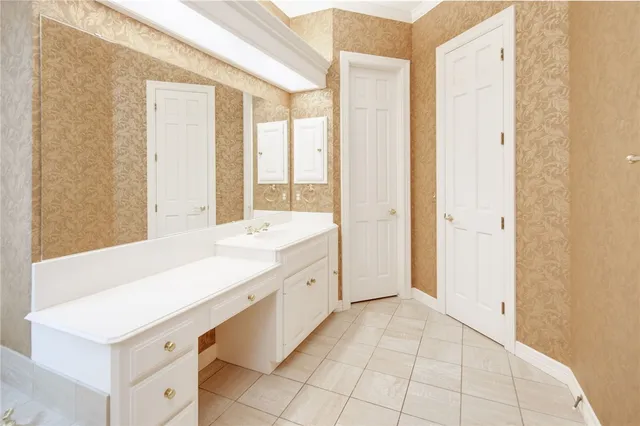 a spacious bathroom with a shower a sink and a large mirror