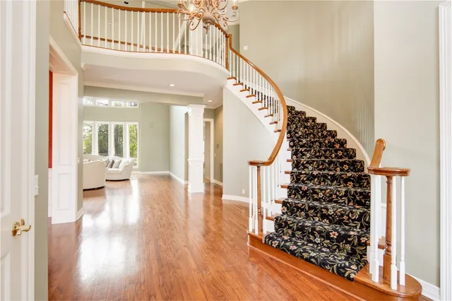 a view of a hallway with wooden floor and staircase