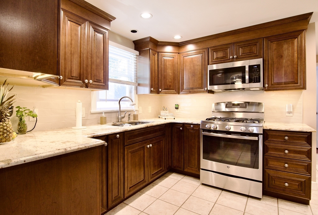 75 Wilton Street Springfield, MA 01109 - Photo 15 of 42 a kitchen with stainless steel appliances granite countertop a sink stove and microwave