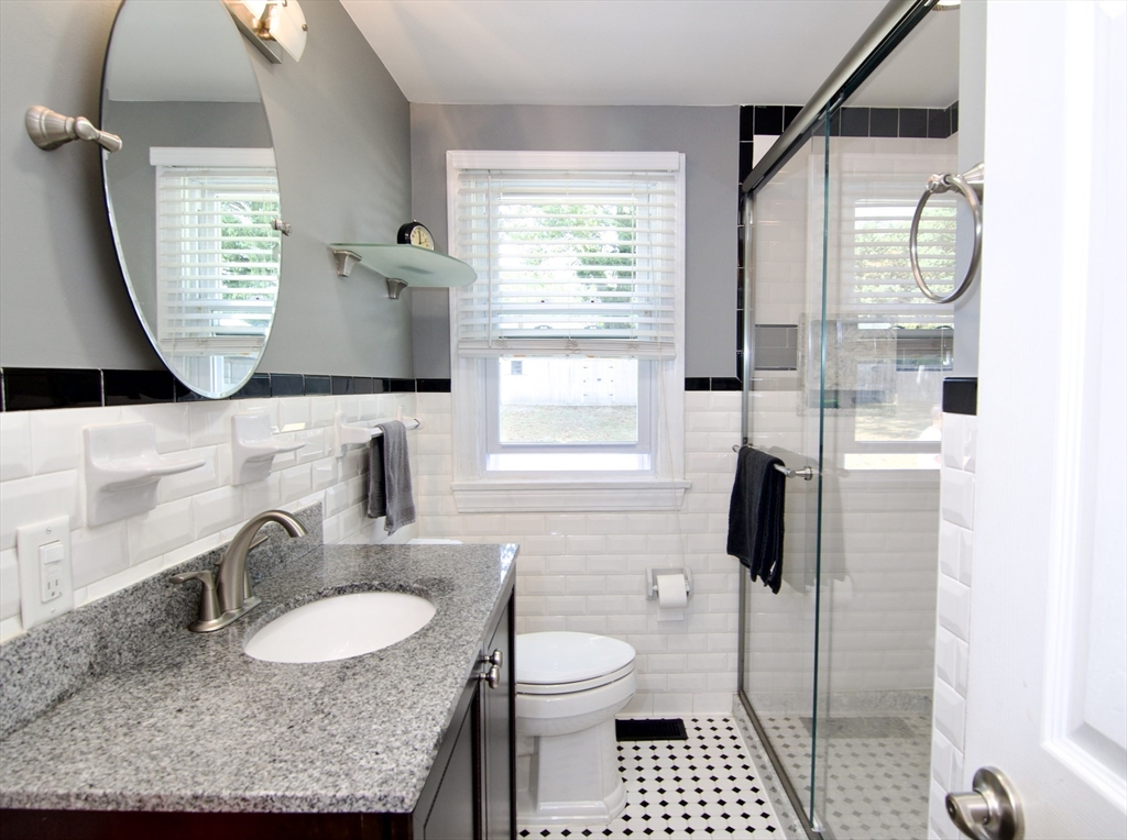75 Wilton Street Springfield, MA 01109 - Photo 22 of 42 a bathroom with a granite countertop sink toilet a mirror and window