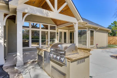 a view of a backyard with potted plants and large tree