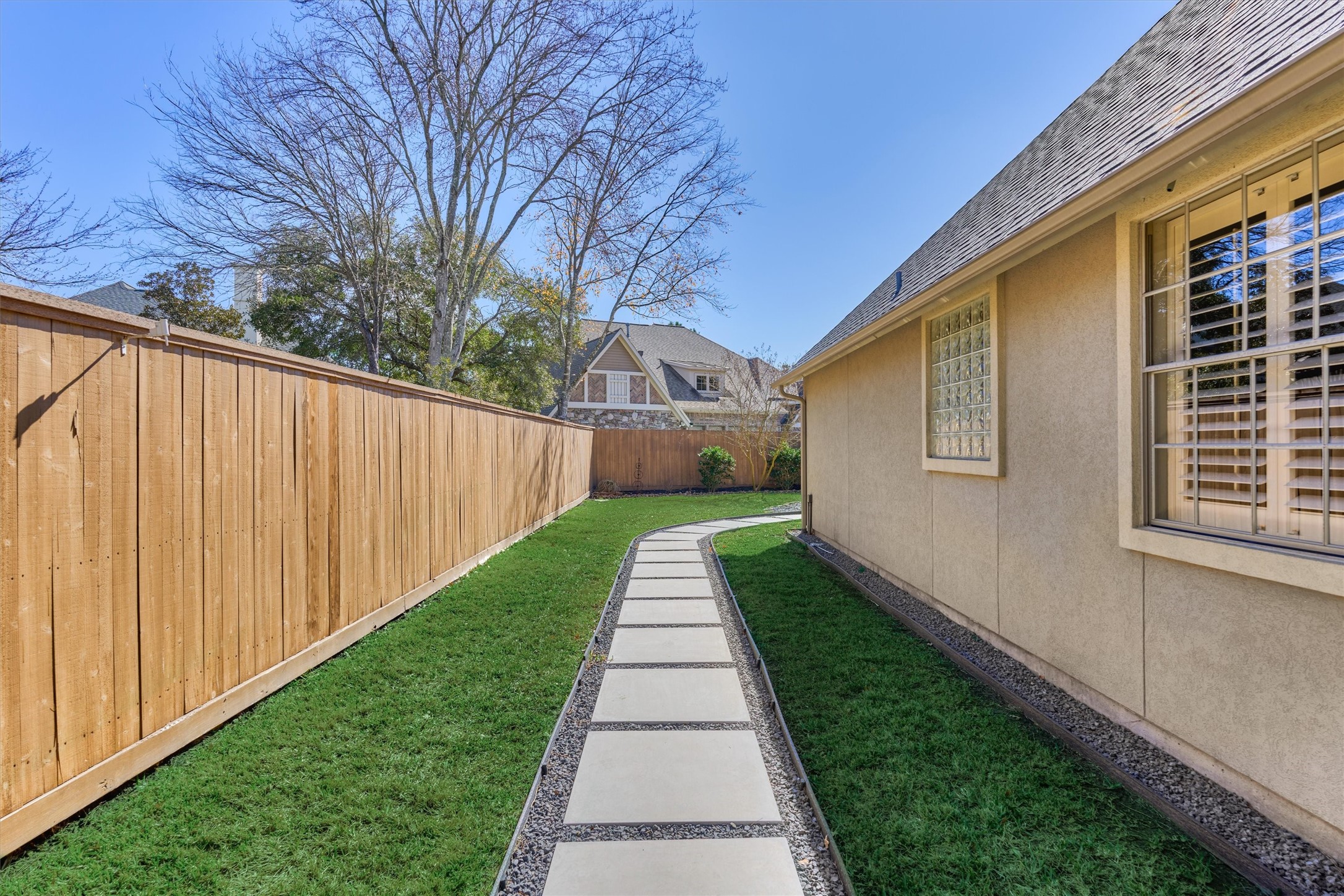 91 West Racing Cloud Court The Woodlands, TX 77381 - Photo 38 of 47 Side yard with walking path shows the owner’s care for utility and design.