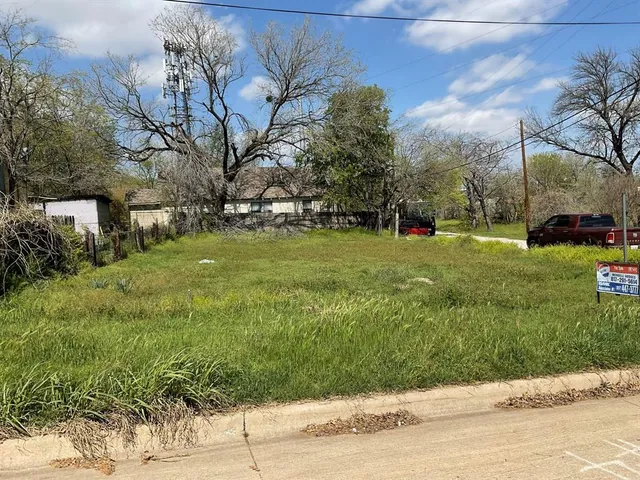 a view of a grassy field with trees