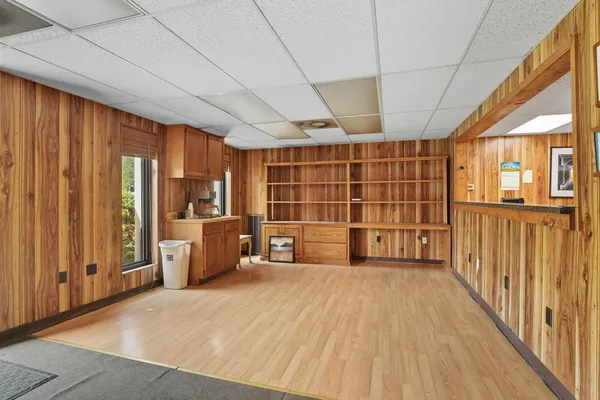 a view of empty room with wooden floor and windows
