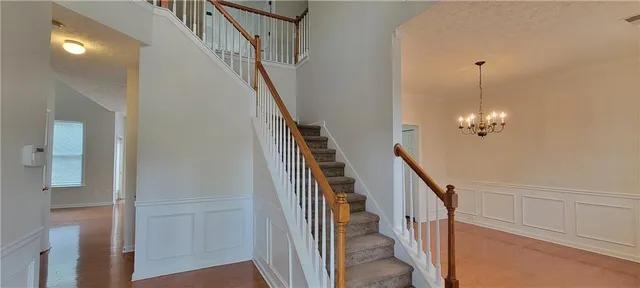a view of a hallway with wooden floor and stairs