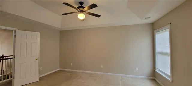 an empty room with a ceiling fan and a window