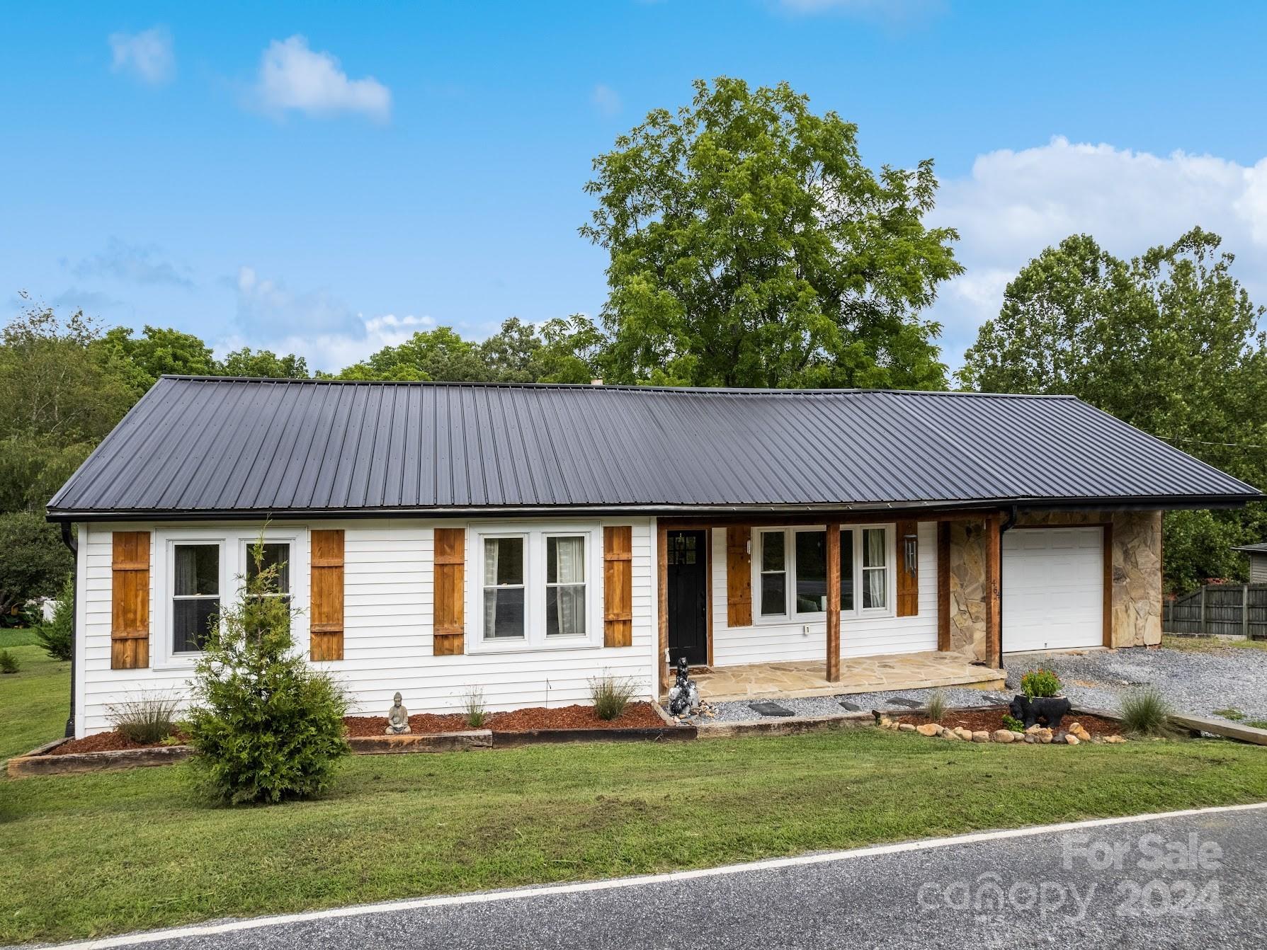 464 Thompson Cove Road Clyde, NC 28721 - Photo 1 of 36 a front view of a house with a garden