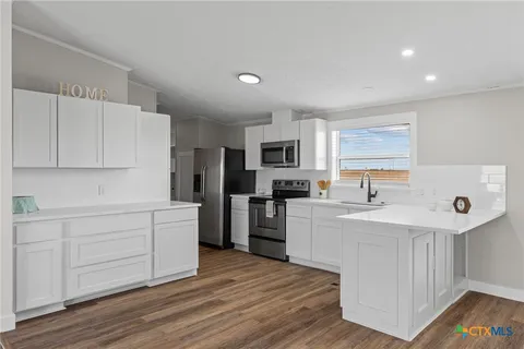 a kitchen with white cabinets and stainless steel appliances