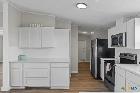 a kitchen with white cabinets and stainless steel appliances
