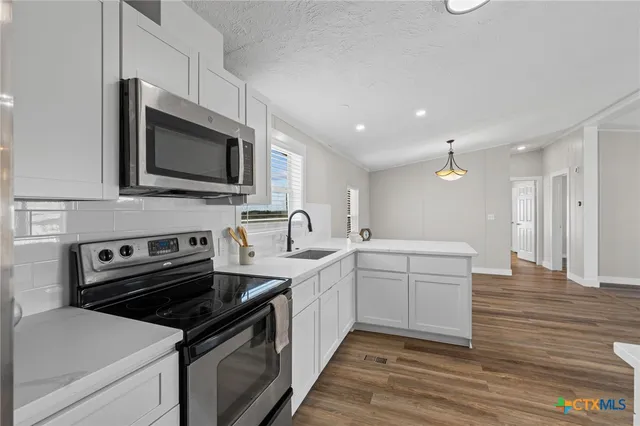 a kitchen with a sink stove and microwave