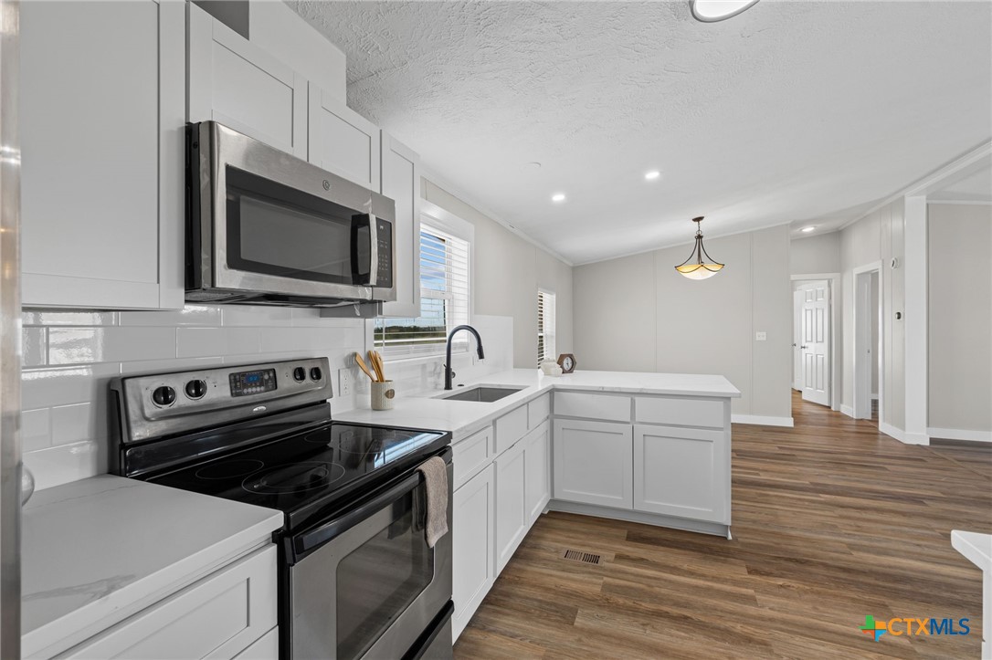 183 Altamira Avenue Elgin, TX 78621 - Photo 15 of 37 a kitchen with a sink stove and microwave