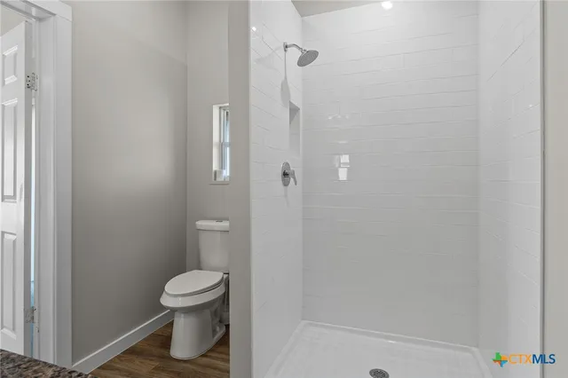 a bathroom with a toilet and a shower