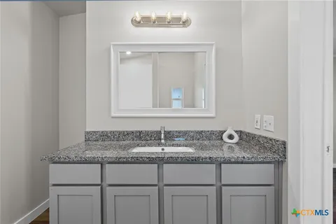 a bathroom with sink granite and mirror