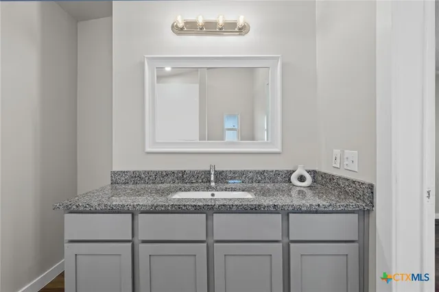 a bathroom with sink granite and mirror