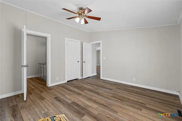 a view of empty room with wooden floor