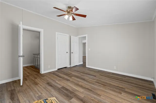 a view of empty room with wooden floor