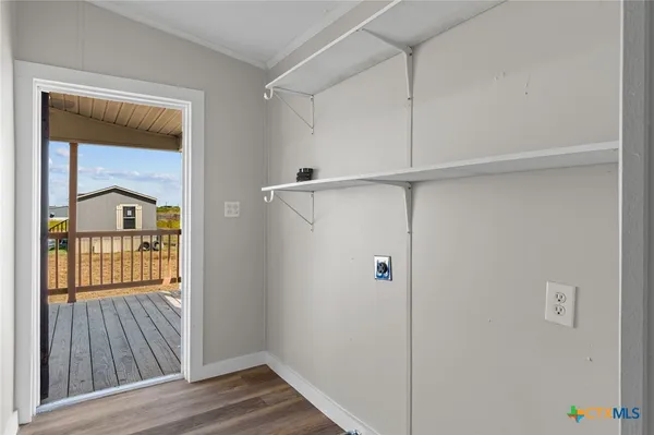 a view of a hallway with wooden floor and a cabinet