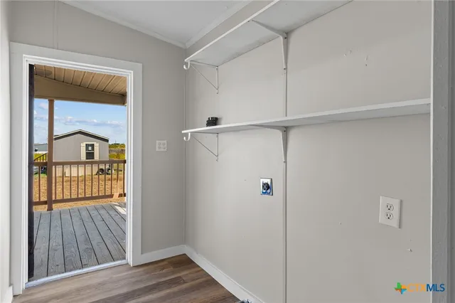 a view of a hallway with wooden floor and a cabinet