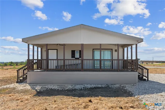 a view of a house with a wooden fence