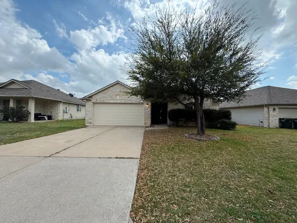 a front view of a house with a yard and a garage